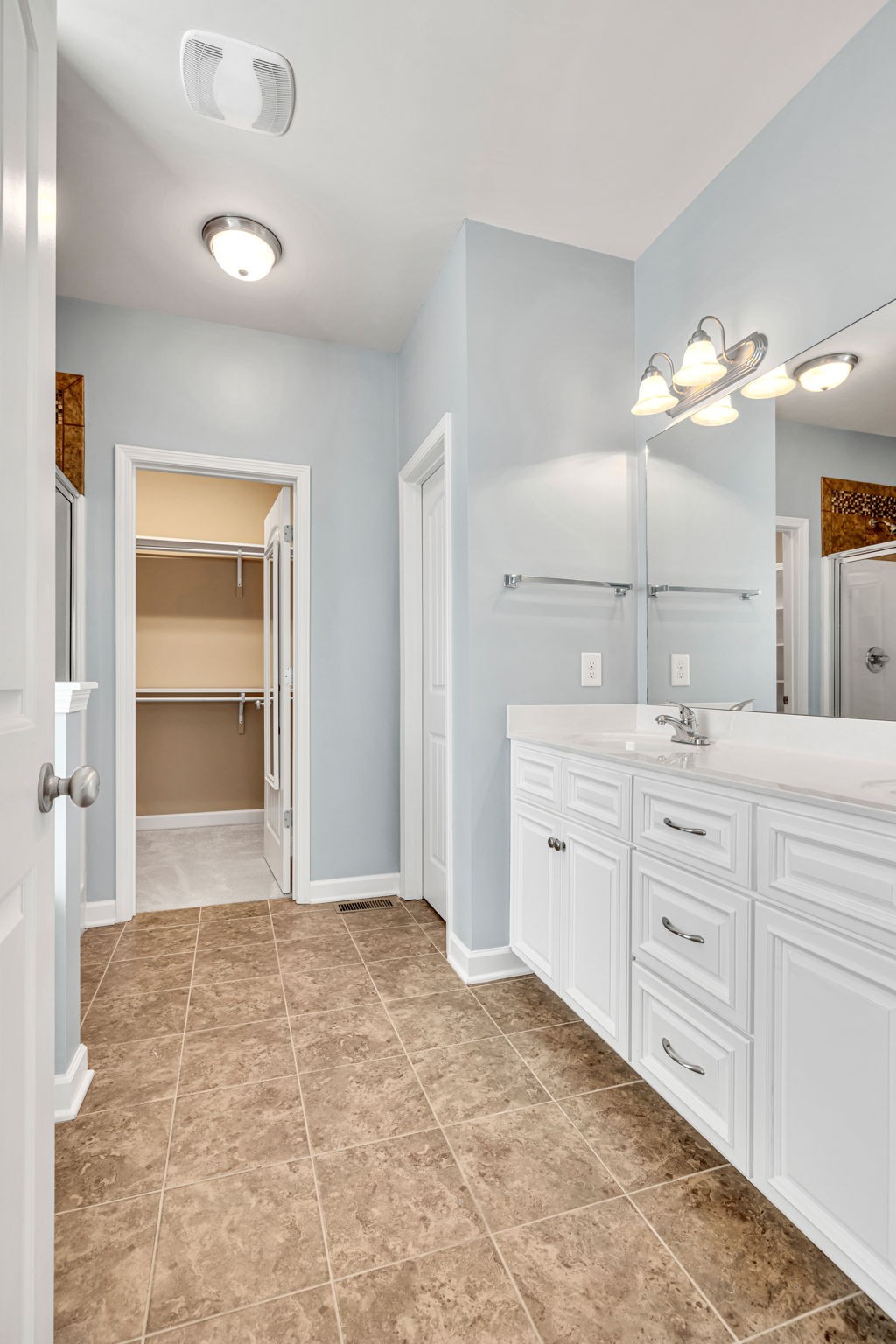8023 Ragusa Circle Spring Hill, TN 37174 - Photo 29 of 46 a spacious bathroom with a granite countertop sink a mirror a vanity and a shower
