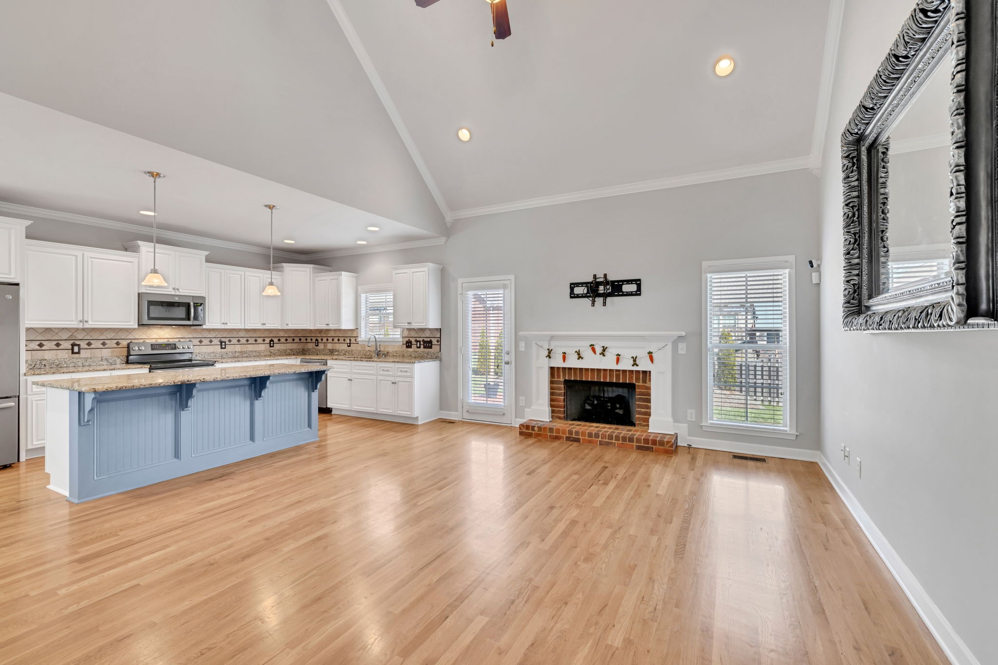 8023 Ragusa Circle Spring Hill, TN 37174 - Photo 6 of 46 a large kitchen with cabinets wooden floor and a fireplace
