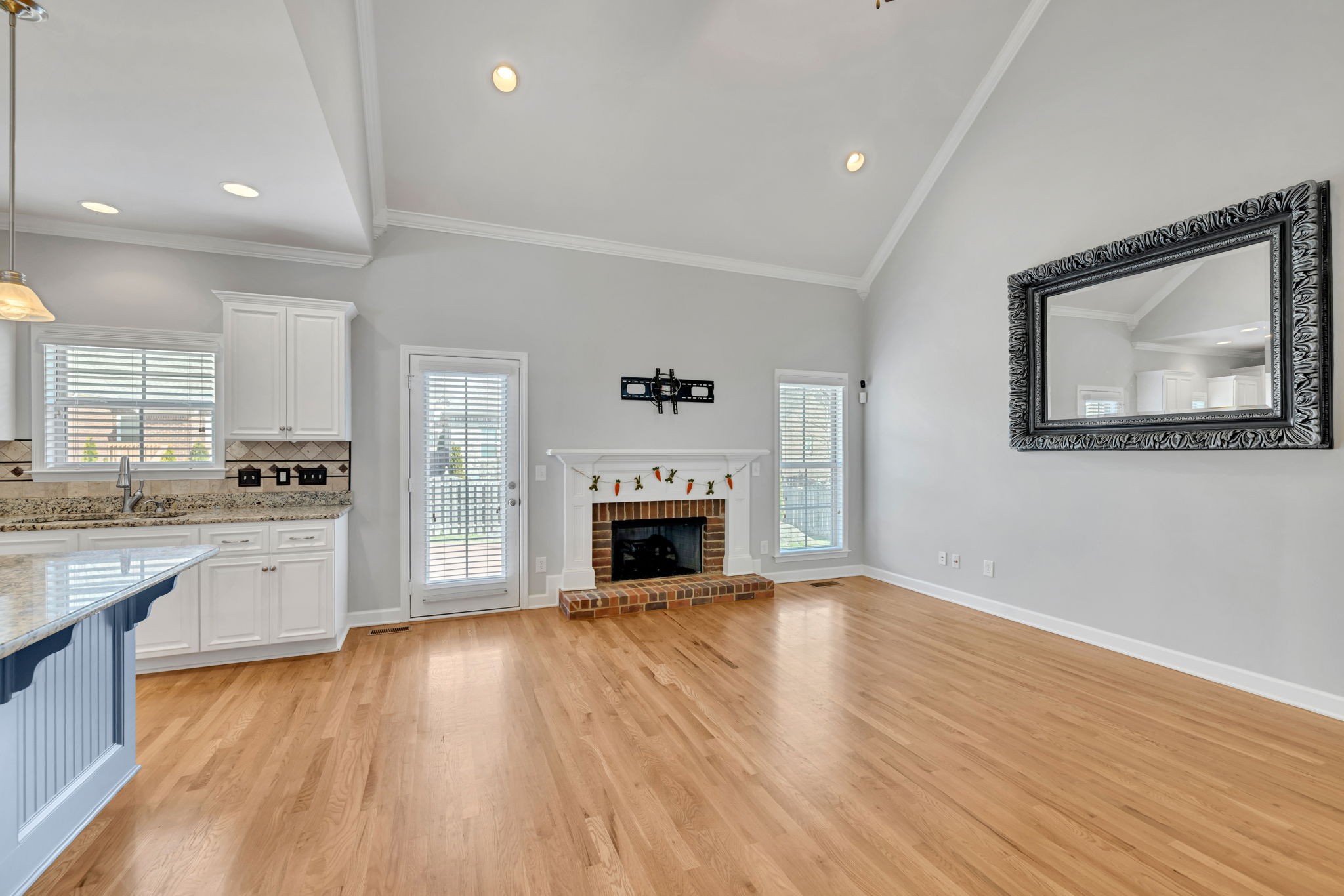 8023 Ragusa Circle Spring Hill, TN 37174 - Photo 8 of 46 a view of kitchen with granite countertop wooden floor a fireplace and a window