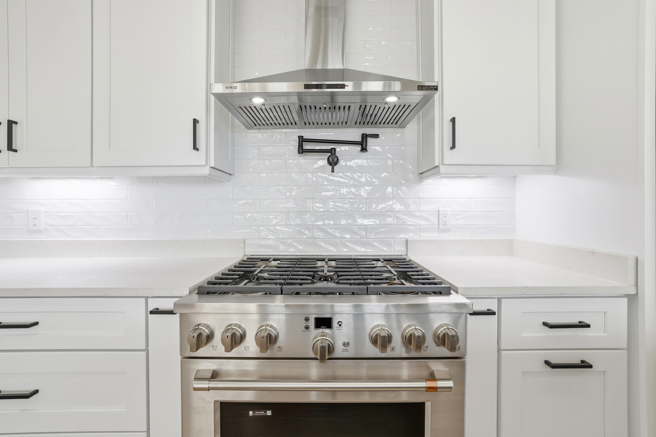 145 Oak Bay Drive Georgetown, SC 29440 - Photo 10 of 39 Kitchen featuring high end range, exhaust hood, white cabinetry, and backsplash
