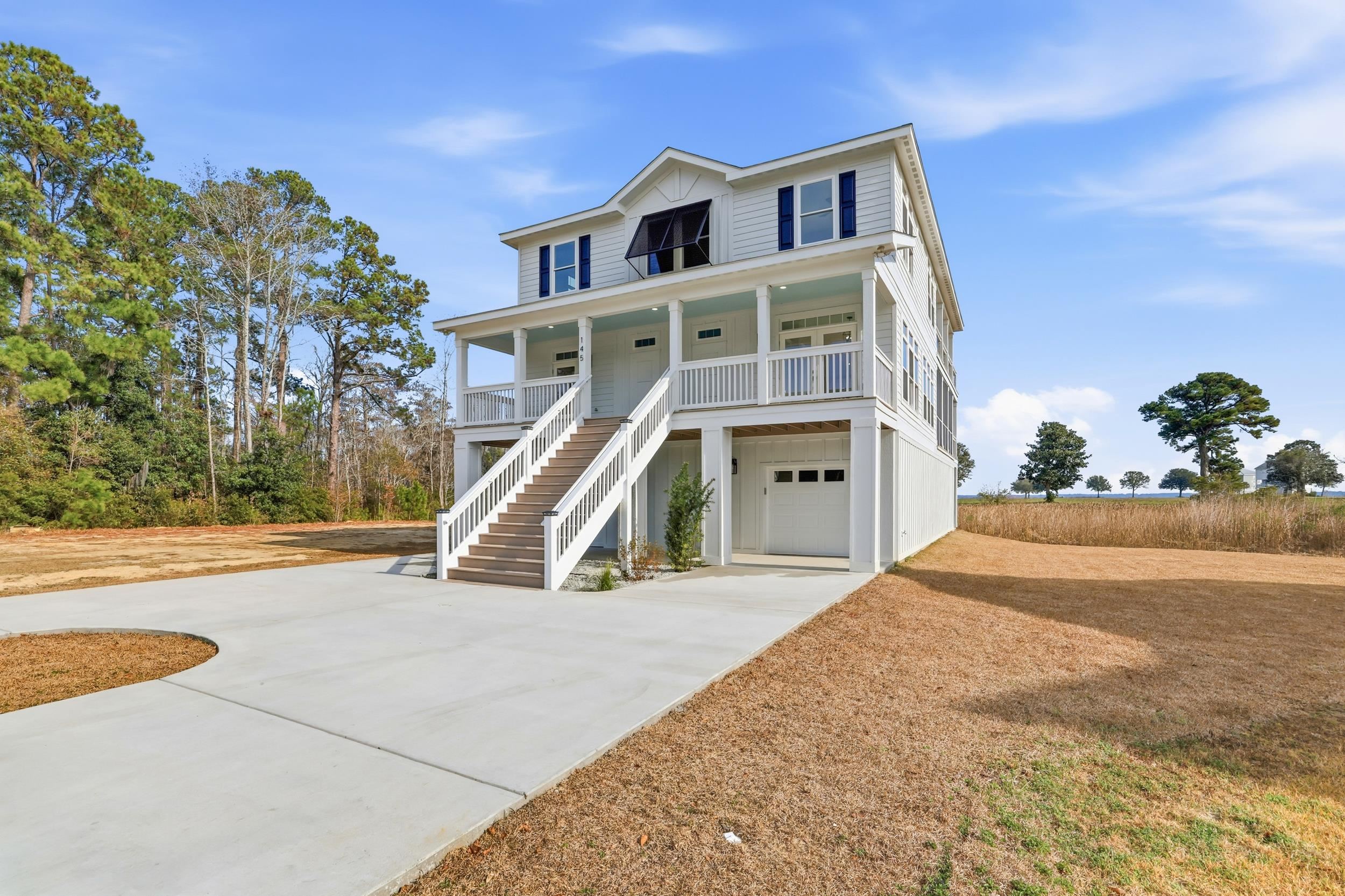 145 Oak Bay Drive Georgetown, SC 29440 - Photo 2 of 39 Coastal inspired home featuring concrete driveway, covered porch, stairway, a garage, and board and batten siding