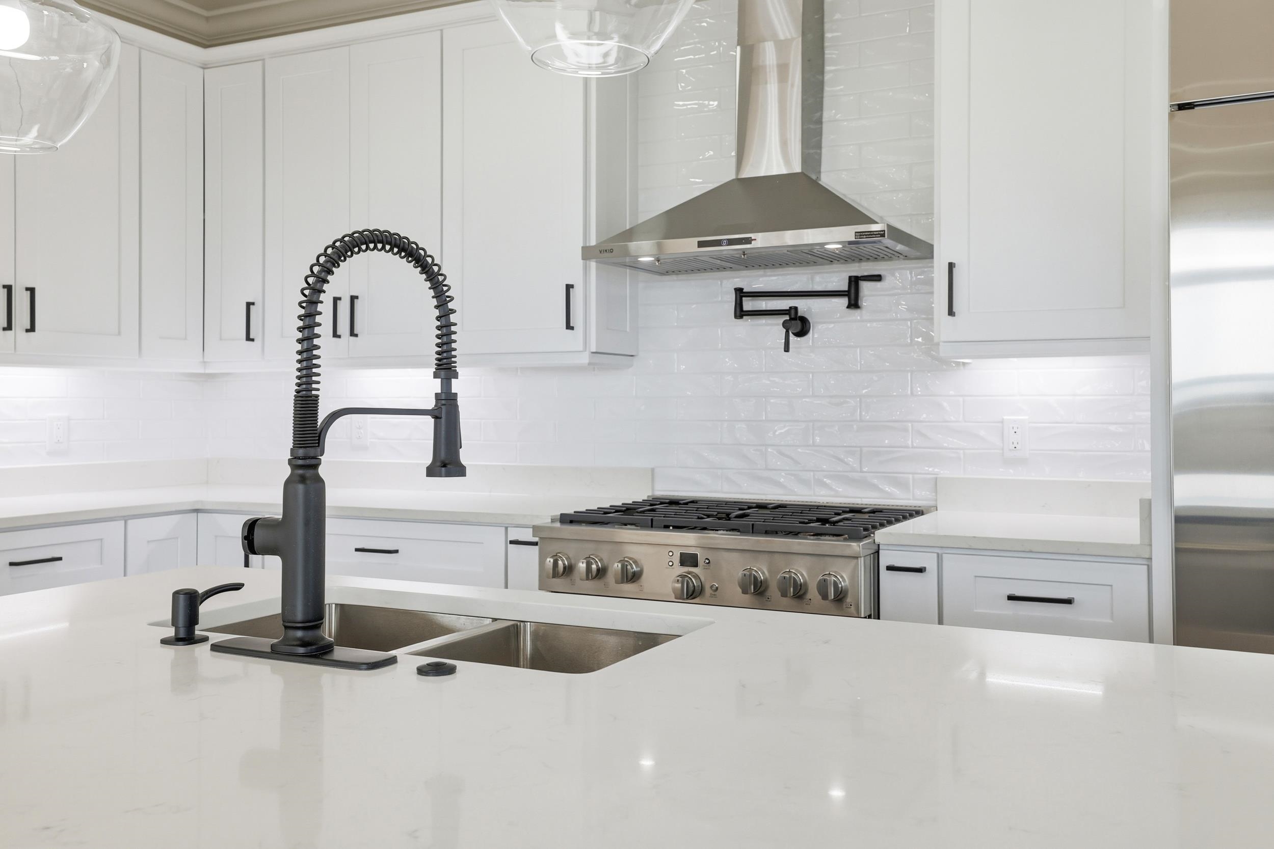 145 Oak Bay Drive Georgetown, SC 29440 - Photo 9 of 39 Kitchen featuring white cabinets, wall chimney exhaust hood, and light stone countertops