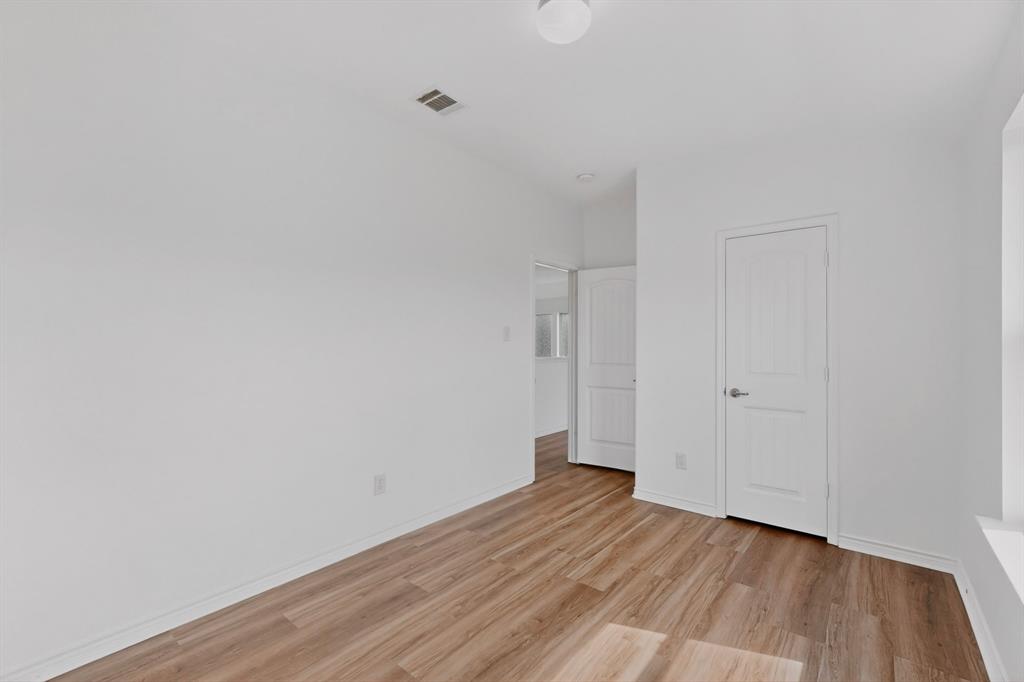 426 Harding Lane Lavon, TX 75166 - Photo 31 of 40 Expansive room featuring wood-finish flooring, white baseboards, and bright white walls