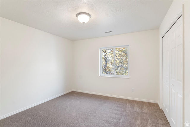 2078 Spring Oaks Drive Springville, UT 84663 - Photo 26 of 40 Unfurnished bedroom with a closet, carpet floors, and a textured ceiling