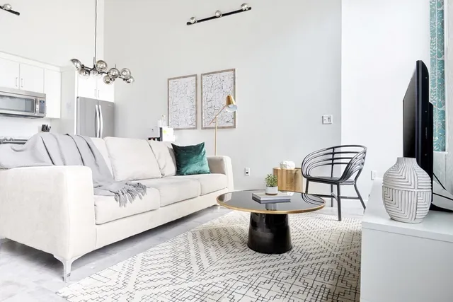 a living room with furniture and a chandelier
