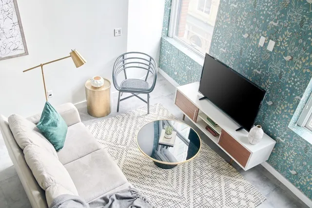 a living room with furniture a flat screen tv and a fireplace