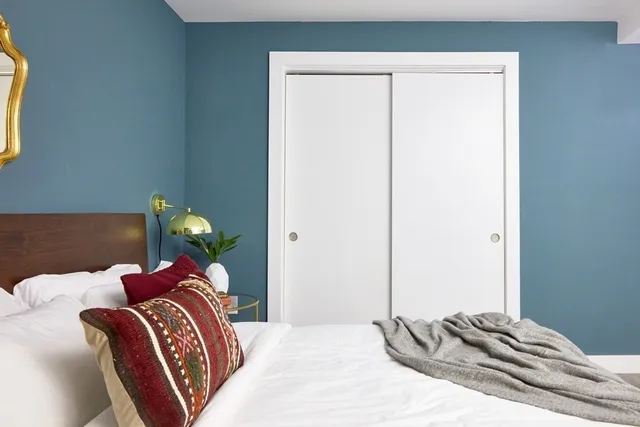 a bedroom with a bed and a lamp