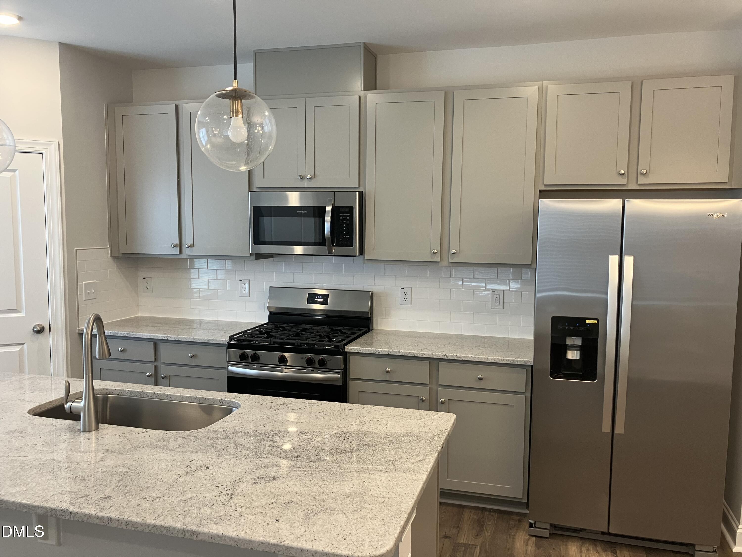 2042 Fishamble Street Fuquay-Varina, NC 27526 - Photo 7 of 15 a kitchen with stainless steel appliances granite countertop a refrigerator a sink a stove and white cabinets