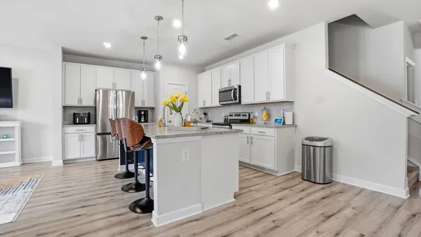 a kitchen with kitchen island white cabinets and stainless steel appliances
