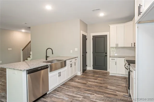 a large white kitchen with a sink and refrigerator