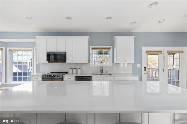 a large white kitchen with a large window