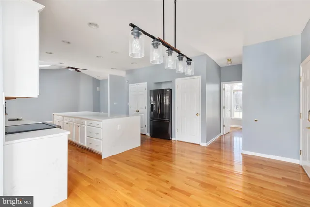 a view of a kitchen with a stove wooden cabinets and a chandelier