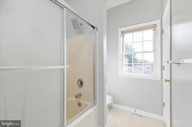 a view of an empty room with window and cabinet