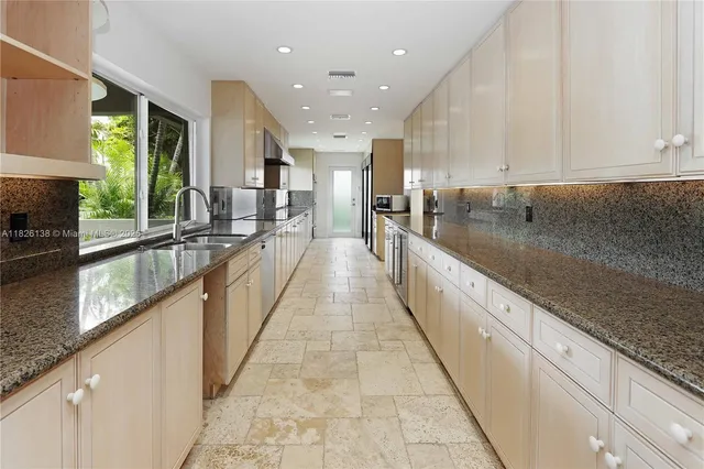 a large white kitchen with a large window