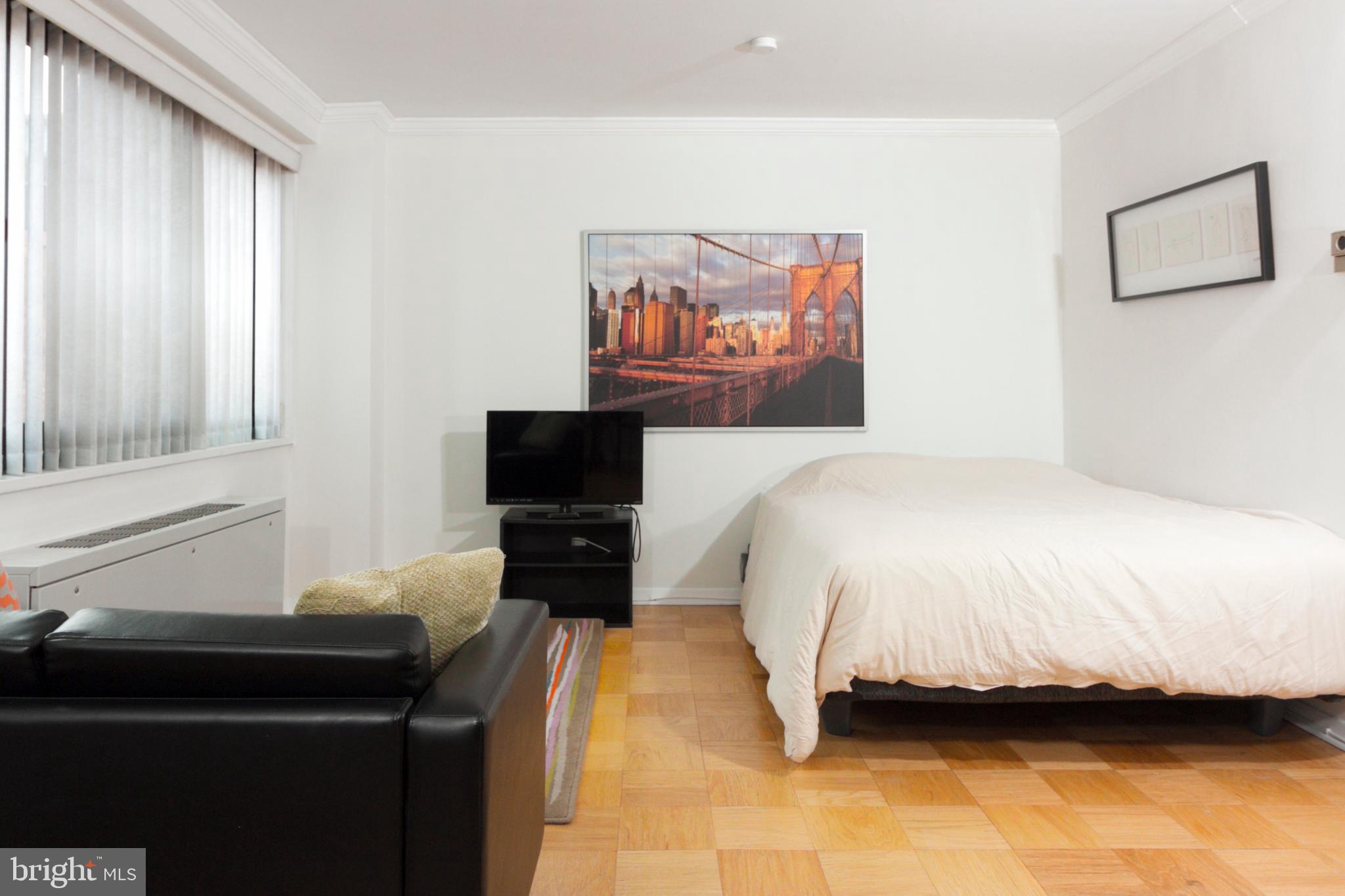 1601 18th Street Northwest, Unit 508 Washington, DC 20009 - Photo 12 of 31 a bedroom with a bed and a flat screen tv