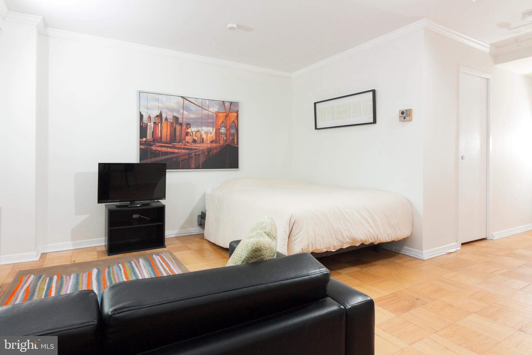 1601 18th Street Northwest, Unit 508 Washington, DC 20009 - Photo 15 of 31 a bedroom with a bed and a couch