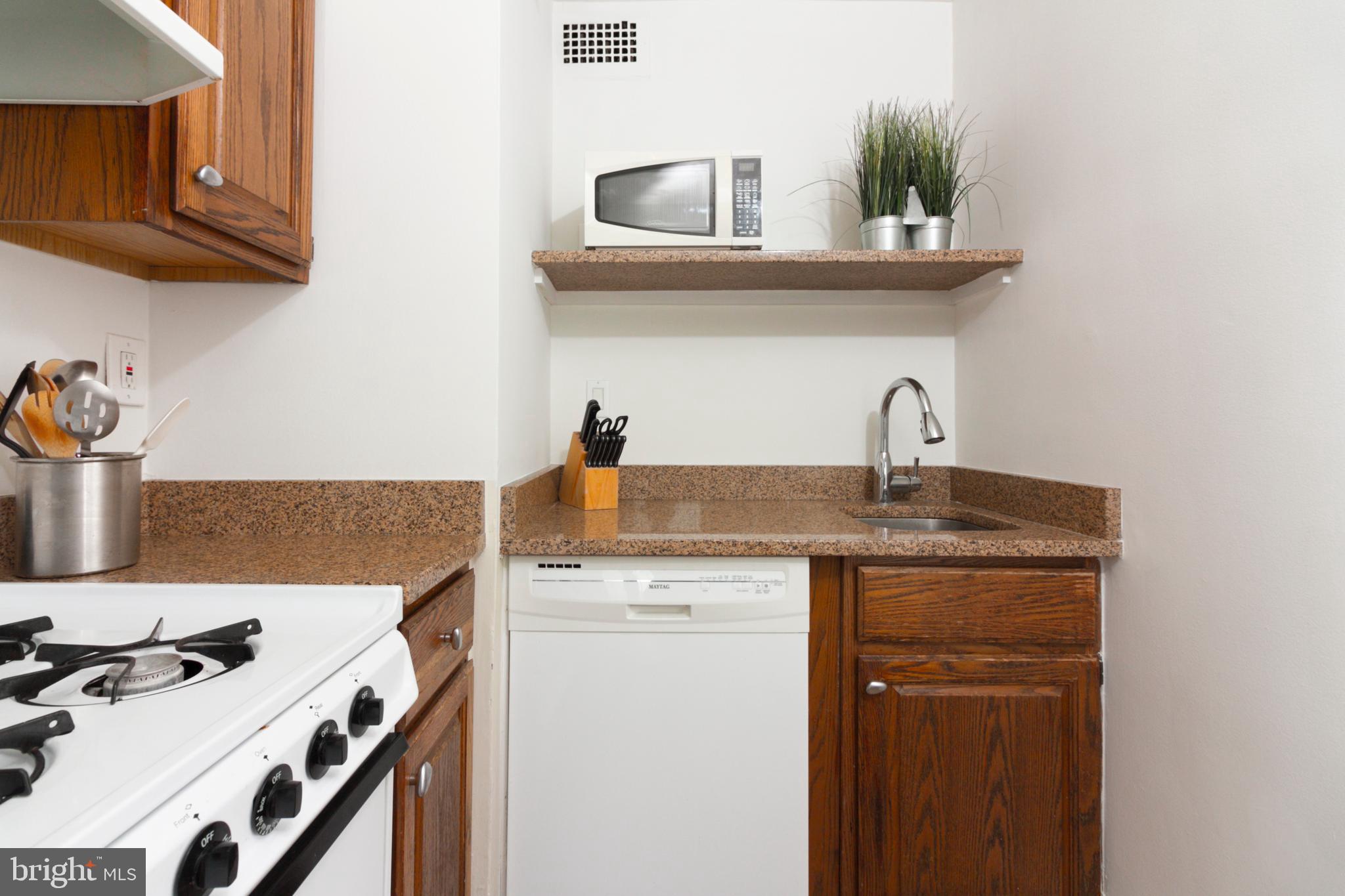 1601 18th Street Northwest, Unit 508 Washington, DC 20009 - Photo 20 of 31 a kitchen with a sink a stove and cabinets