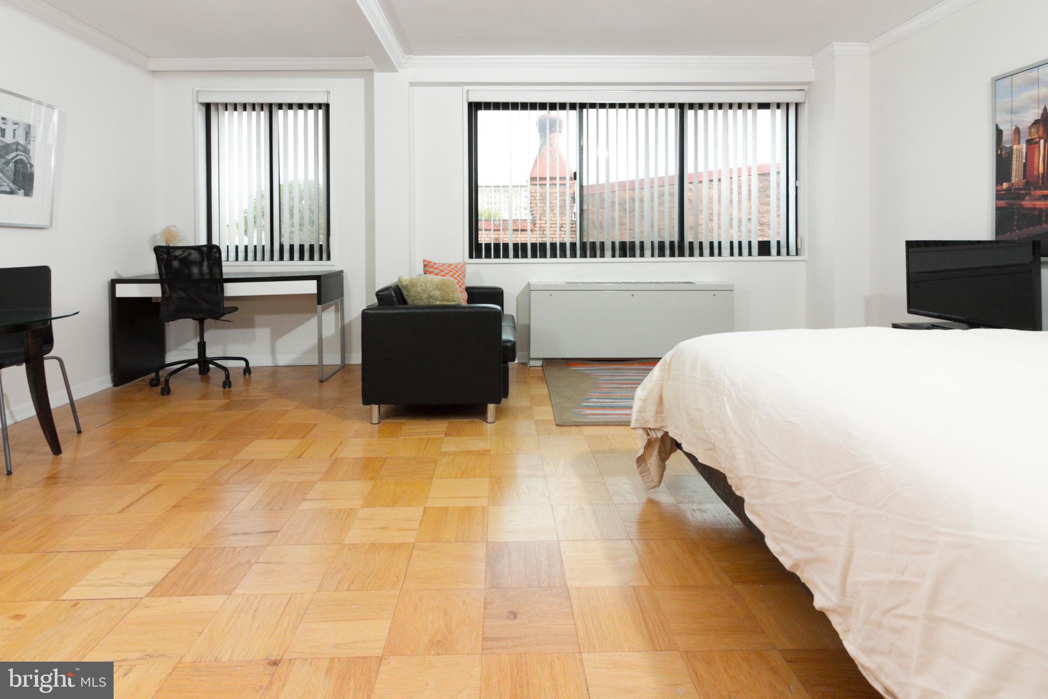 1601 18th Street Northwest, Unit 508 Washington, DC 20009 - Photo 9 of 31 a bedroom with a bed and a large window