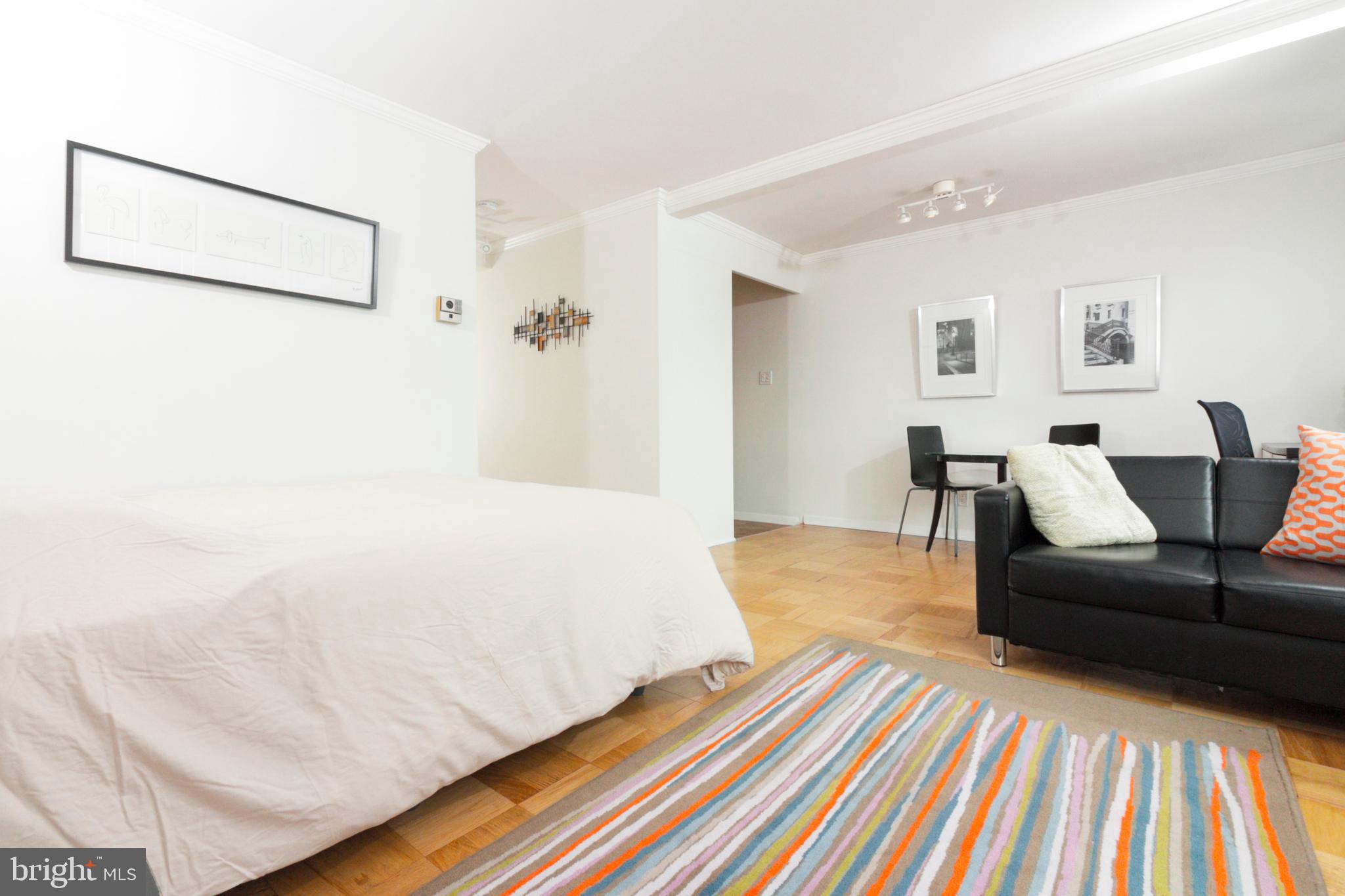 1601 18th Street Northwest, Unit 508 Washington, DC 20009 - Photo 10 of 31 a spacious bedroom with a bed and a couch