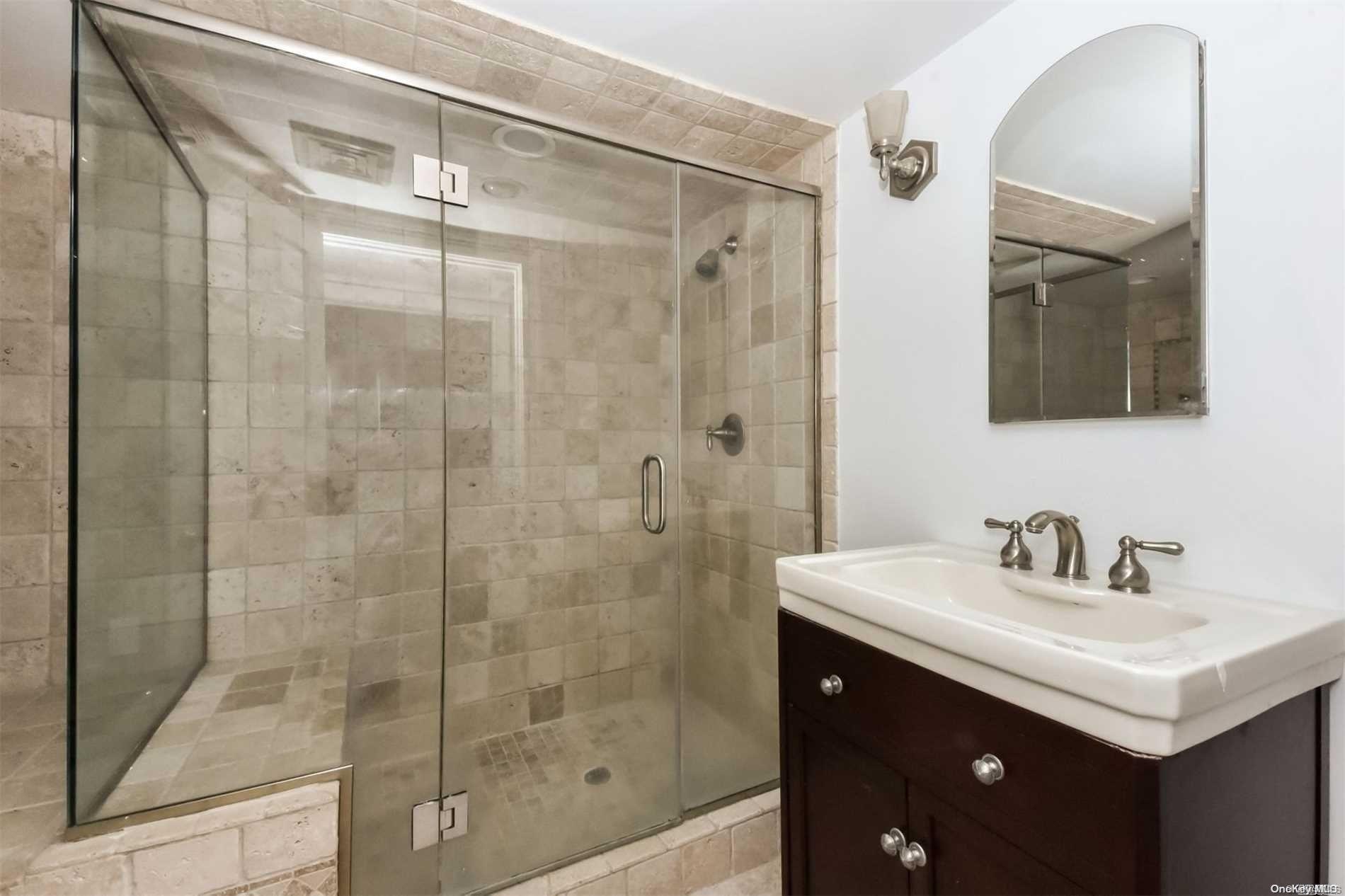 1 Parish Drive Locust Valley, NY 11560 - Photo 12 of 19 a bathroom with a shower sink and mirror