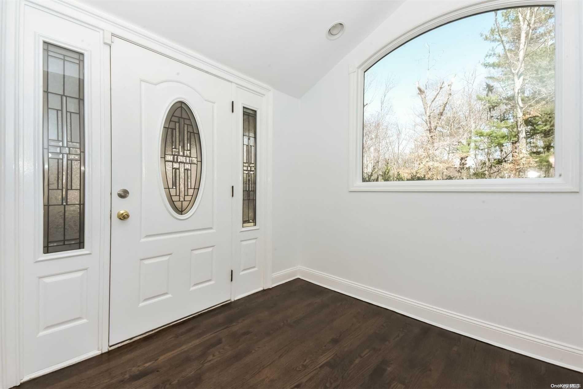 1 Parish Drive Locust Valley, NY 11560 - Photo 2 of 19 an empty room with wooden floor and white walls