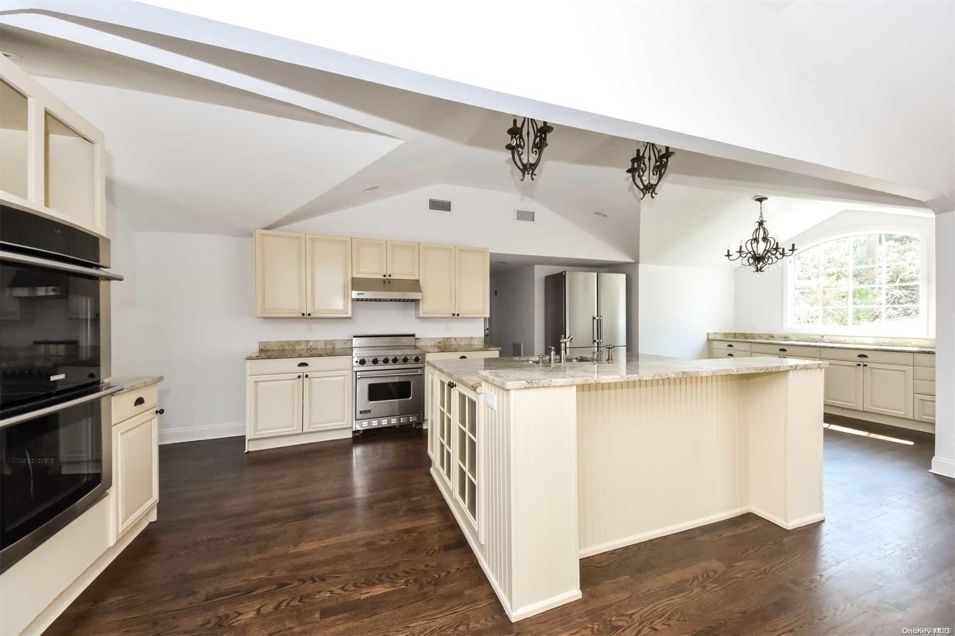 1 Parish Drive Locust Valley, NY 11560 - Photo 4 of 19 a kitchen with stainless steel appliances kitchen island granite countertop a stove a sink and a refrigerator