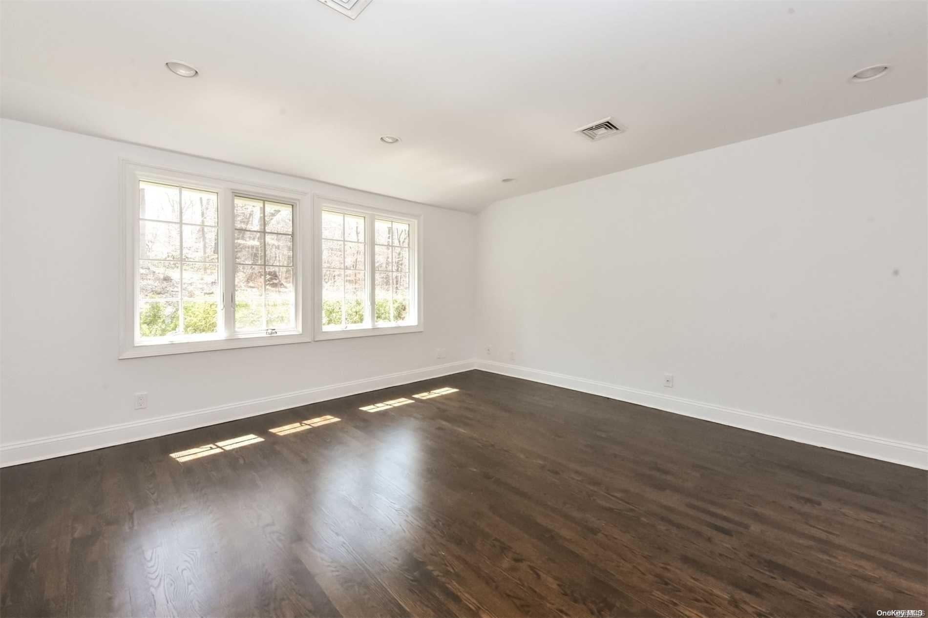 1 Parish Drive Locust Valley, NY 11560 - Photo 9 of 19 an empty room with wooden floor and windows