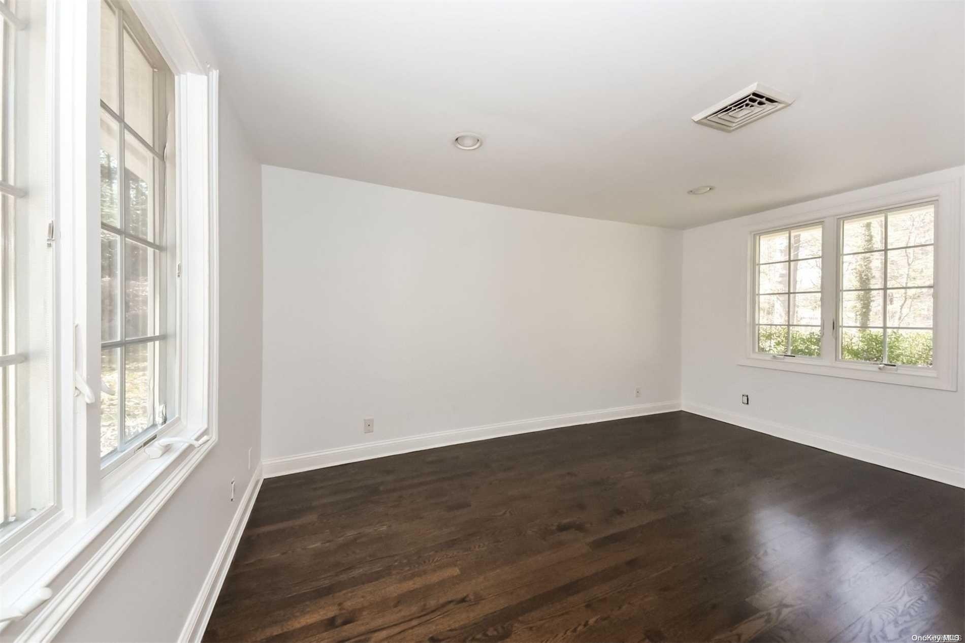 1 Parish Drive Locust Valley, NY 11560 - Photo 10 of 19 a view of an empty room with wooden floor and a window