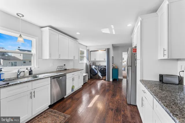 a large kitchen with a lot of counter space and wooden floor
