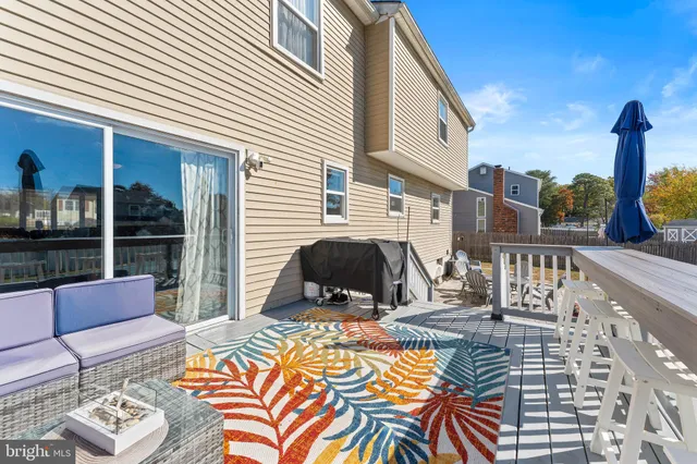 a view of a roof deck with couches chairs and wooden floor