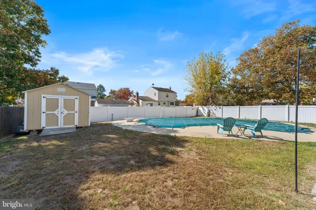 a view of a house with backyard and trees