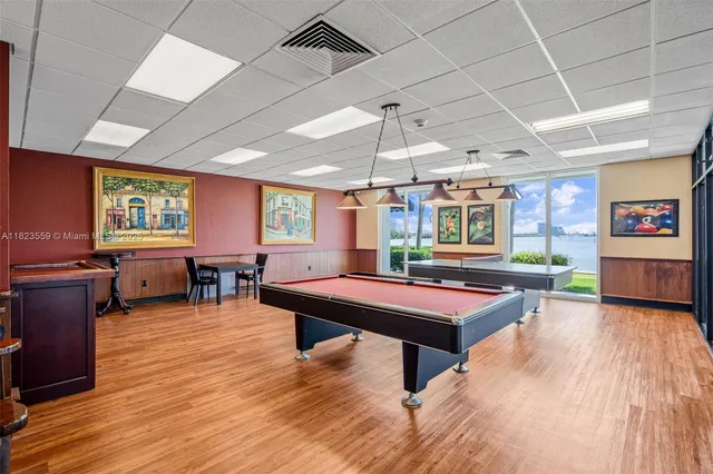 a room with furniture pool table wooden floor and windows