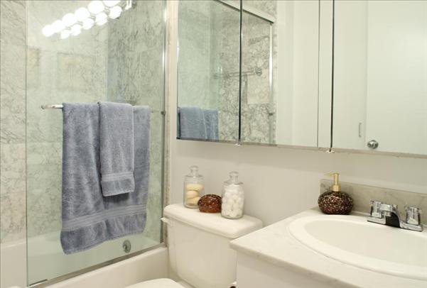 Undisclosed Address Manhattan, NY 10022 - Photo 10 of 14 a bathroom with a tub shower sink and mirror
