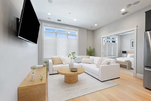 a living room with furniture a flat screen tv and a large window