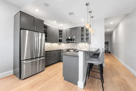 a kitchen with kitchen island a counter top space a refrigerator a sink and a stove