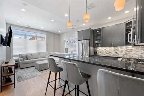 a living room with stainless steel appliances kitchen island granite countertop furniture and a large window