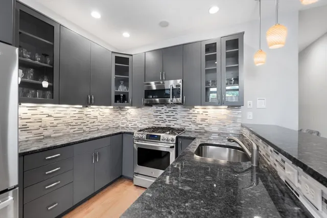 a kitchen with stainless steel appliances granite countertop sink stove and cabinets