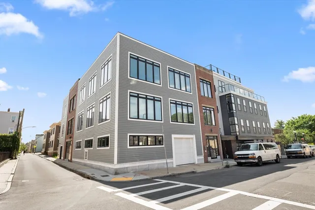 a city street lined with buildings and cars parked on the roadside