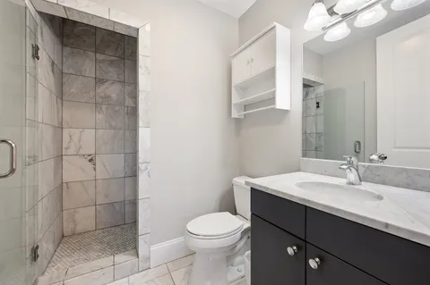 a bathroom with a sink a toilet and shower