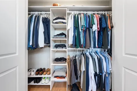 a view of walk in closet with clothes and shoes