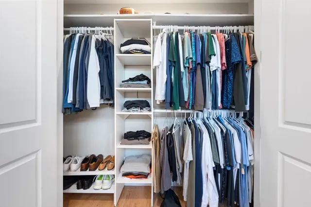 a view of walk in closet with clothes and shoes