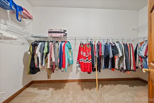 a view of walk in closet with clothes