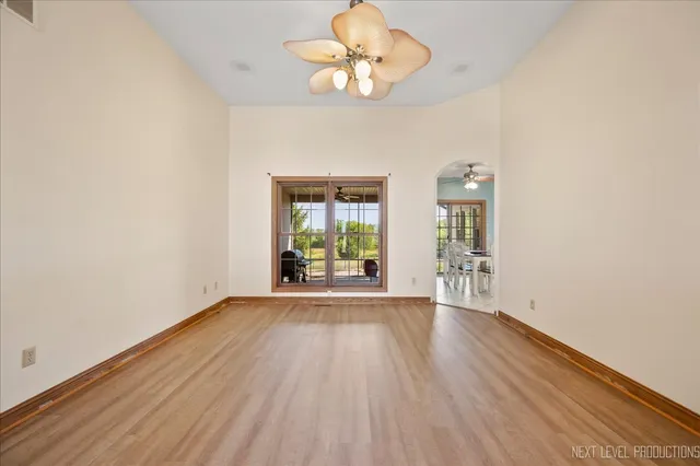 a view of an empty room with a window and wooden floor