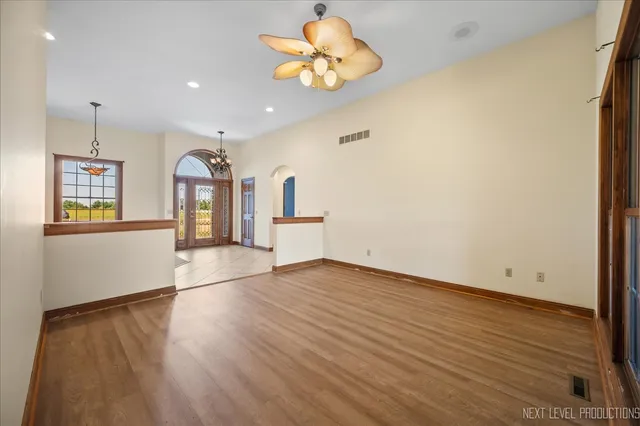 a view of an empty room with window and wooden floor
