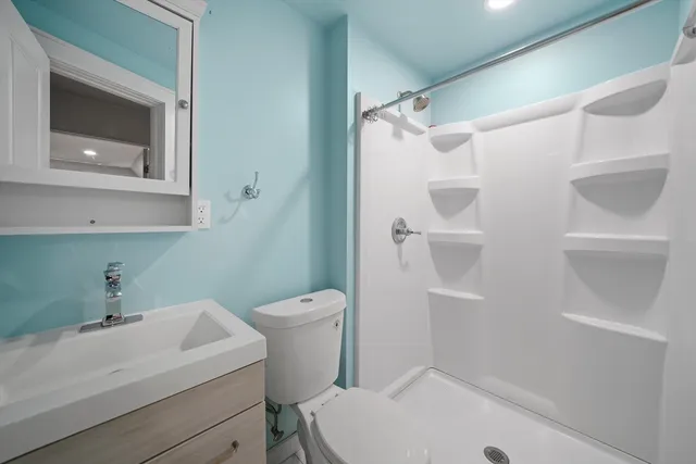 a bathroom with a sink a toilet and shower