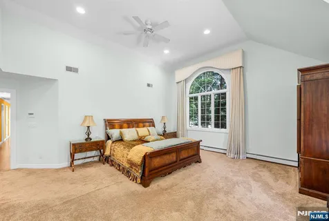 a spacious bedroom with a bed and a large window