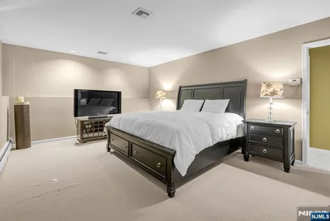 a spacious bedroom with a bed and a tv