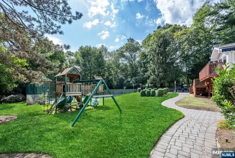 a view of a house with a yard fire pit and a large tree