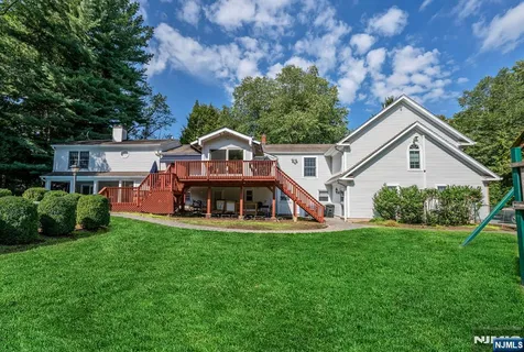 a view of a house with a big yard plants and large trees