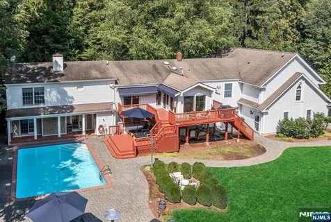 an aerial view of a house with swimming pool garden and patio